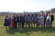 Studierende und Lehrkräfte stehen vor einem Zaun