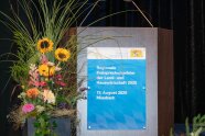 Rednerpult mit Plakat und Blumendekoration